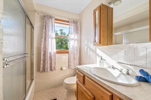 a bathroom with a sink and a toilet and a window at HV Spacious Retreat sleeps 13 with pool and hot tub in Poughkeepsie