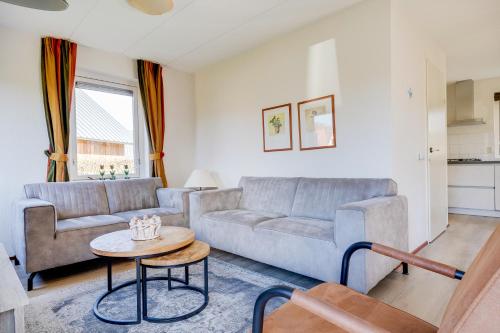 a living room with a couch and a table at Koekoek I Modern Huis met Privé Tuin in Zwiggelte