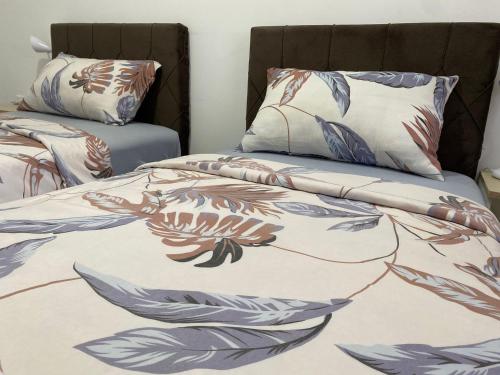 a bedroom with two beds with a blanket and pillows at Prenoćište SILVER LUX Srebrno Jezero 13 in Veliko Gradište