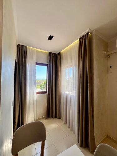 a living room with curtains and a window at Kamberi Hotel & Apartments in Velipojë