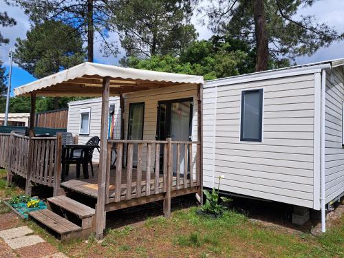 a white tiny house with a porch and a table at Camping du Domaine de la Forge in La Teste-de-Buch