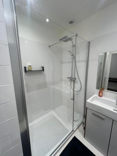une douche avec une porte vitrée à côté d'un lavabo dans l'établissement Luxury Flat étoile Champs Élysée 16th arrondissement, à Paris