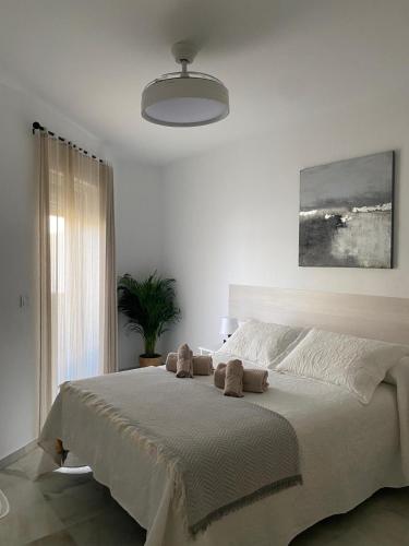 a bedroom with a large bed with two stuffed animals on it at Apartamento Capillera 9 in El Puerto de Santa María