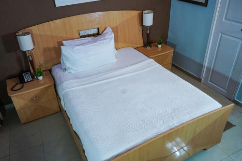 a bedroom with a bed with a wooden head board at EKA ELITE HOTEL in Lomé