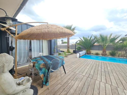 - une terrasse avec une table et un parasol dans l'établissement La villa DOLCE, à Le Bouscat