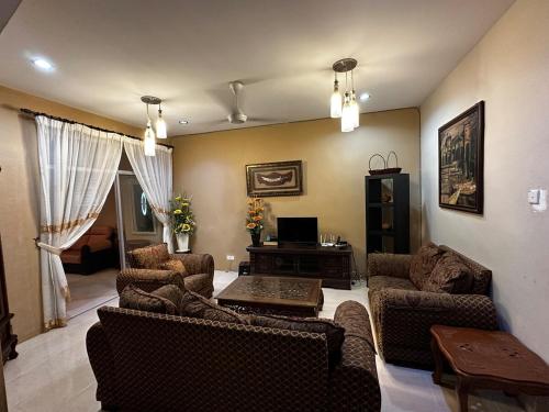 a living room with two couches and a table at The Deck Homestay & Event House in Jitra
