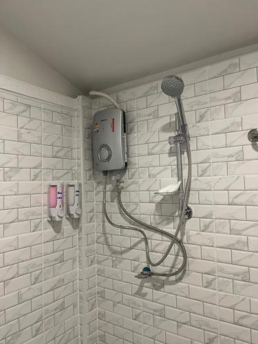 a shower in a white tiled bathroom at SPL Betong Family Room in Betong