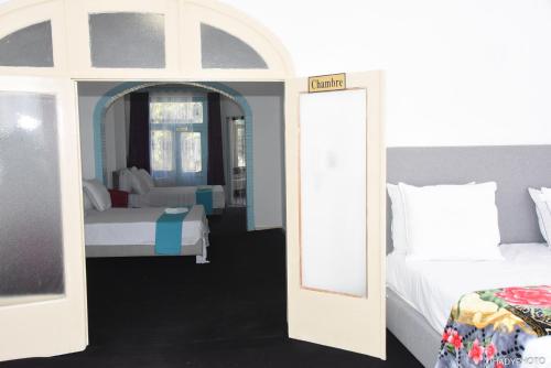 a bedroom with two beds and a mirror at Hébergement confort Garé de l'ouest in Brussels