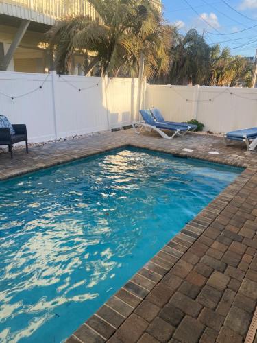 a swimming pool with two chairs in a backyard at Latitude adjustment, walk to beach in Myrtle Beach