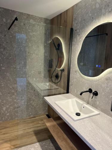 a bathroom with a sink and a shower at Pokoje Gościnne Lidka in Dziwnów