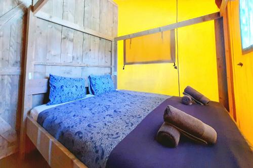 a bedroom with a bed with blue and yellow walls at Silver Coast Glamping luxury lodge in Alcobaça