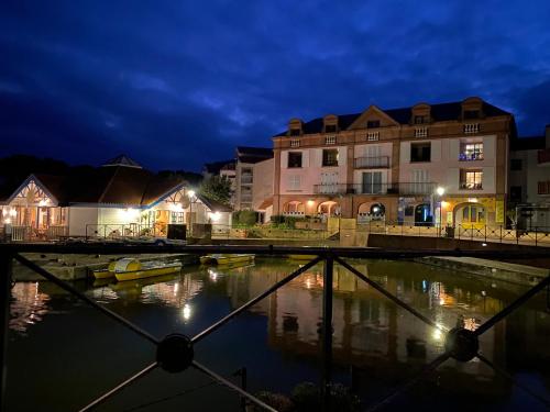 a view of a river at night with buildings at Vue lac à 5 minutes de la mer in Talmont