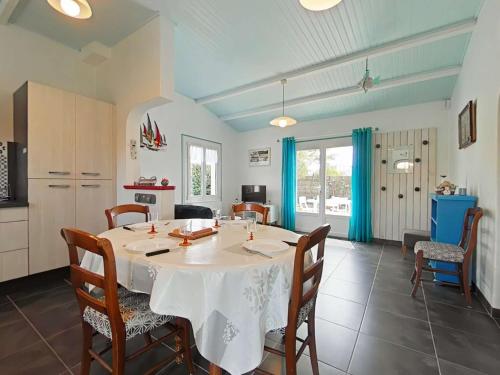 une cuisine et une salle à manger avec une table et des chaises dans l'établissement Maison de vacances à 600m de la plage, jardin clos, terrasse plein sud, 5 couchages, Noirmoutier - FR-1-224B-618, à Noirmoutier-en-l'lle
