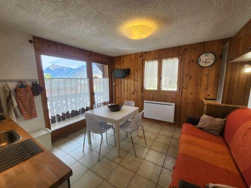 un salon avec une table et un canapé dans l'établissement Studio cabine avec balcon et parking, à 2 pas des télécabines de Morillon - FR-1-629-74, à Morillon