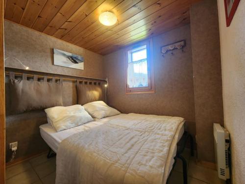 une chambre avec un lit dans une pièce avec une fenêtre dans l'établissement Studio cabine avec balcon et parking, à 2 pas des télécabines de Morillon - FR-1-629-74, à Morillon