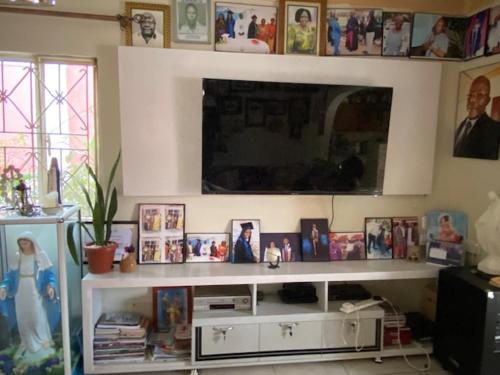 a living room with a white shelf with pictures on it at Green Enchantment Home in Nalakonge