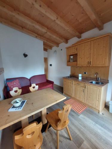 a kitchen with a wooden table and a couch at Camping Al Lago Ledro in Ledro
