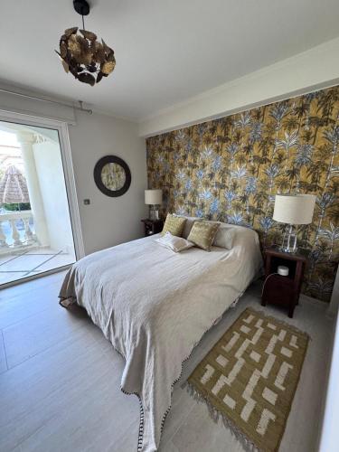 une chambre avec un grand lit et une grande fenêtre dans l'établissement Magnifique suite dans villa de luxe, à La Colle-sur-Loup