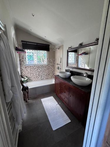 La salle de bains est pourvue de 2 lavabos, d'une baignoire et d'une baignoire. dans l'établissement Magnifique suite dans villa de luxe, à La Colle-sur-Loup