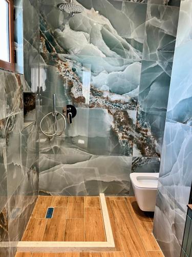 a bathroom with a painting of clouds on the wall at Kamberi Hotel & Apartments in Velipojë