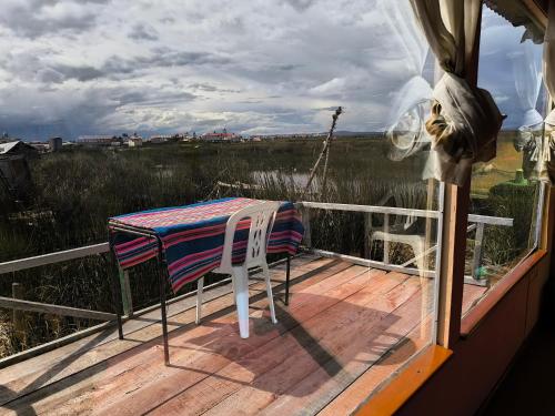 a table and a chair on a deck at Uros Casa de Yolanda in Puno