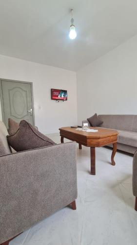 a living room with a couch and a coffee table at Apartement near the Airport and beach Gzenaya in Gzennaïa
