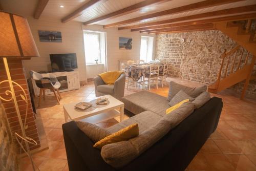un salon avec un canapé et une table dans l'établissement Maison au bord de la Ria, BBQ et babyfoot inclus !, à Plouhinec