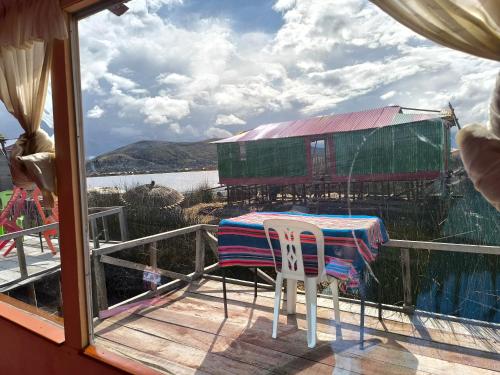 a table and a chair on a deck with a view at Uros Casa de Yolanda in Puno
