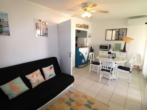 un salon avec un canapé et une table dans l'établissement Spacieux 3 Pièces Climatisé avec Terrasse et Garage - FR-1-307-281, au Grau-du-Roi