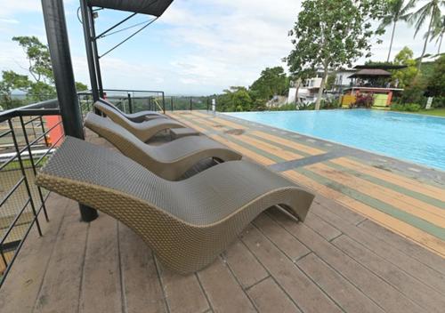 a row of chairs sitting on a deck next to a pool at Magarra Hotel in Orani