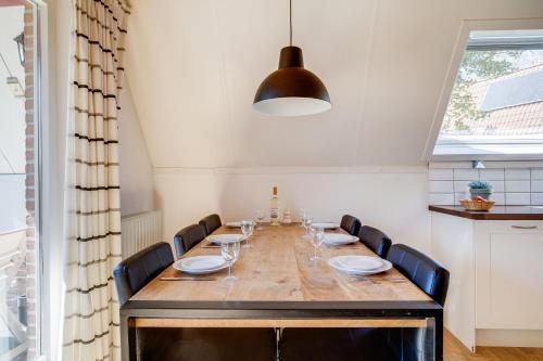 a dining room with a long table with chairs at Nachtegaal I Vakantiewoning met Mooie Tuin in Zwiggelte
