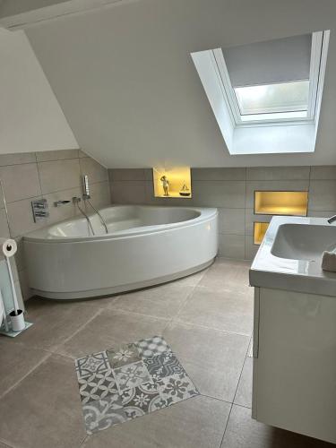 a large bathroom with a tub and a sink at Landhaus Chica in Salzgitter