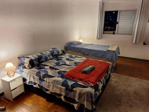 ein Schlafzimmer mit zwei Betten und einem Tisch darin in der Unterkunft Casinha na Vila Madalena in São Paulo