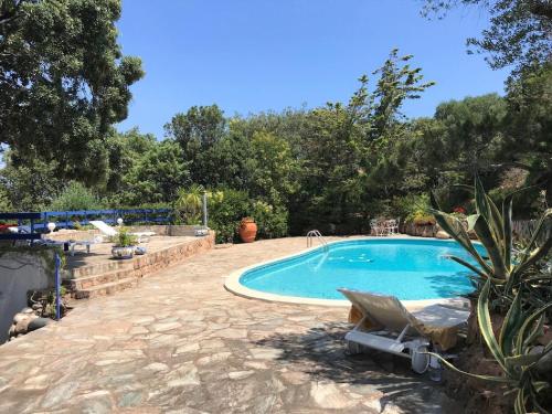 - une piscine dans une cour avec une chaise dans l'établissement Casa Blue Cala Rossa with Pool, à Lecci