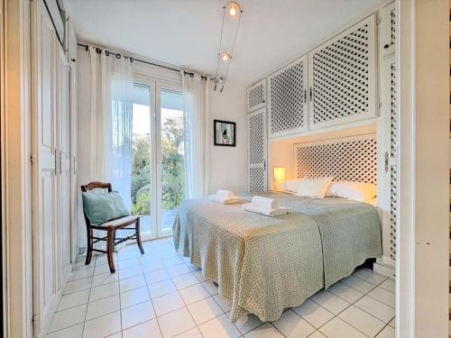 une chambre avec un lit, une chaise et une fenêtre dans l'établissement Casa Blue Cala Rossa with Pool, à Lecci