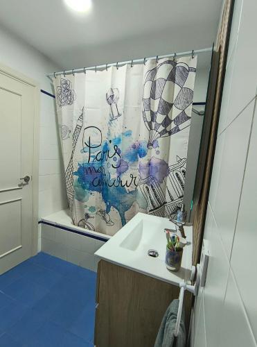 a bathroom with a sink and a shower curtain at Apartamento Capillera 9 in El Puerto de Santa María