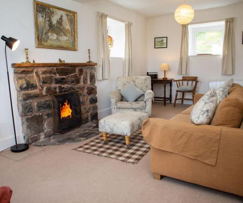 a living room with a couch and a fireplace at Garnllys Farmhouse Fishguard in Fishguard