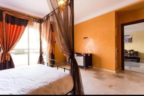 a bedroom with a bed and a large window at Élégant Appartement de Standing à la Marina in Agadir
