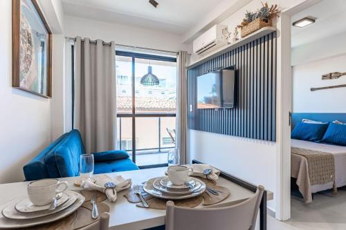 a living room with a dining room table and a bed at Flat no Centro 1 Quarto com varanda - 50m Piscinas das Naturais in Porto De Galinhas