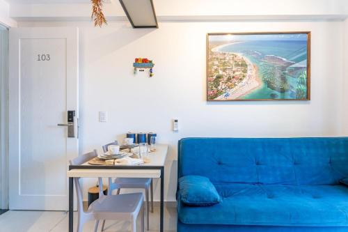 a living room with a blue couch and a table at Flat no Centro 1 Quarto com varanda - 50m Piscinas das Naturais in Porto De Galinhas