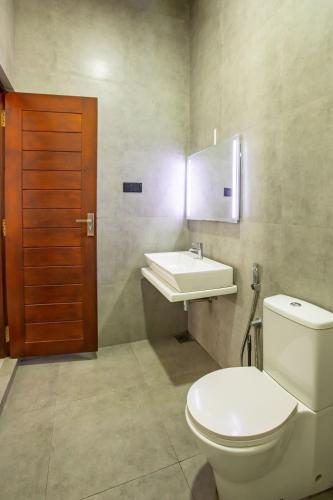 a bathroom with a toilet and a sink at Spacious Home with Rooftop Pool in Malabe