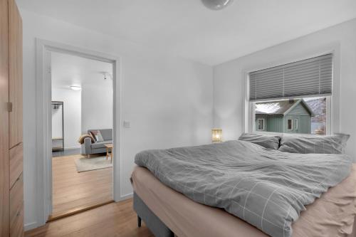 une chambre blanche avec un lit et une fenêtre dans l'établissement 2-bedroom modern apartment in Tromsø, à Tromsø
