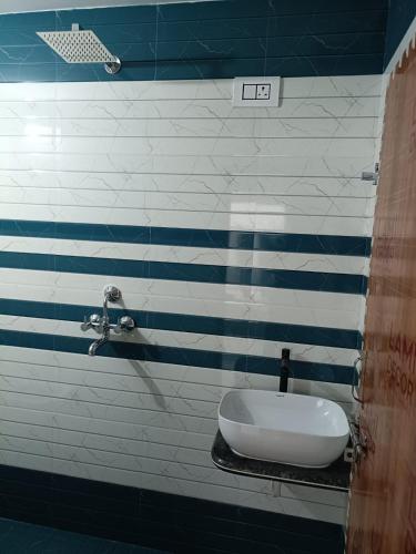 a bathroom with blue and white stripes on the wall at PARADISE GUEST HOUSe in Bikaner