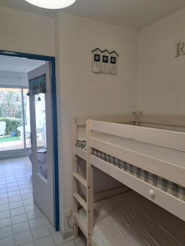 Cette chambre comprend 2 lits superposés et une porte ouverte. dans l'établissement Mer et soleil LGM, à La Celle-sous-Gouzon