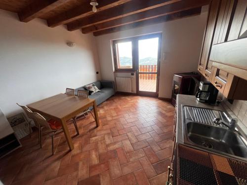 a kitchen and living room with a table and a couch at Relax con vista in Costa Valle Imagna