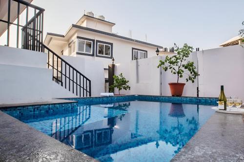 a swimming pool in front of a house at Thor Villa, 5BHK-Private Pool-Cook-Caretaker in Assagao