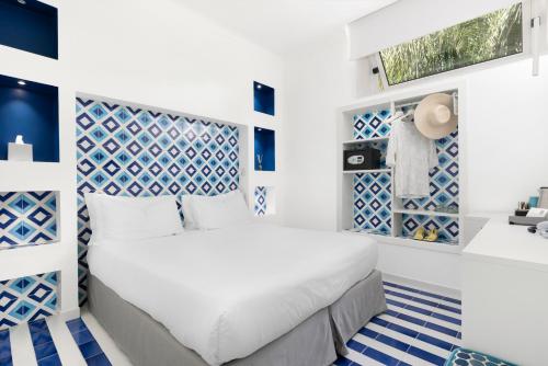 a bedroom with a white bed and blue and white floors at Hotel Bougainville in Positano
