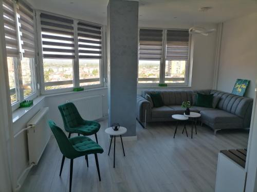 a living room with a couch and chairs and windows at MaFi apartment in Bitola