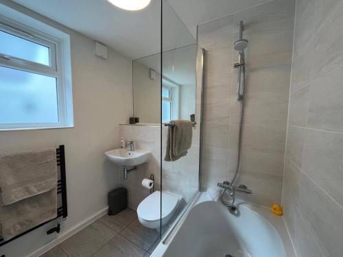 a bathroom with a tub and a toilet and a sink at Charming 3-Bed Cottage - Private Garden & Parking in Torquay