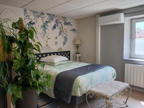 une chambre avec un lit et une plante dans l'établissement Gîte La Lusitanie, à Morteau